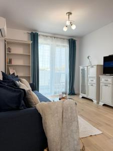 a living room with a blue couch and a tv at Eox Luxury Studio & Apartment Center Cathedral Palas with parking in Iaşi
