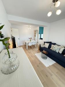 a living room with a blue couch and a table at Eox Luxury Studio & Apartment Center Cathedral Palas with parking in Iaşi