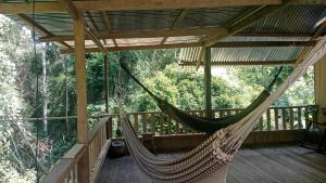 a hammock on the deck of a tree house at Hostal Ebenezer Macedonia in Macedonia