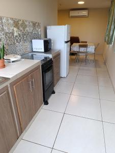 a kitchen with a refrigerator and a table at Apart 2 habitaciones vista a Itaipú - 32 in Ciudad del Este