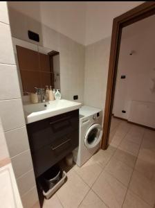 Un baño con lavabo y lavadora. en Bergamo's little flat, en Villa dʼAlmè