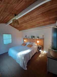 a bedroom with a large bed and a wooden ceiling at Villa familiale aux portes du Médoc et de Bordeaux in Blanquefort