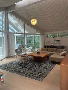 a living room with a table and a couch at Large Holiday Home Close To Nature in Tikøb