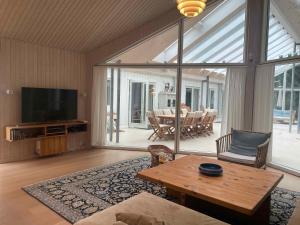 a living room with a television and a table at Large Holiday Home Close To Nature in Tikøb