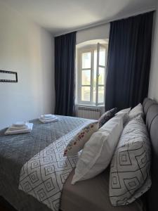 a bedroom with a bed with pillows and a window at Zen Old Town in Mostar