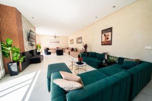 a large living room with green couches and chairs at Viva La Villa in Marrakech
