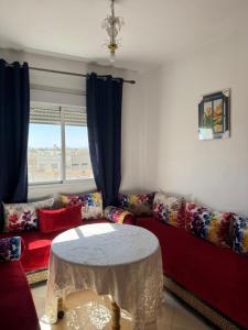 a living room with a red couch and a table at Fès comfort stay in Fès