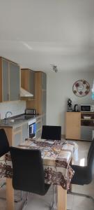 a kitchen with a table and some chairs and a table and a counter at Ferienwohnung am Waldrand in Herdwangen-Schönach