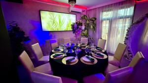 a dining room with a table and purple lighting at PENSIUNEA Ana in Buftea