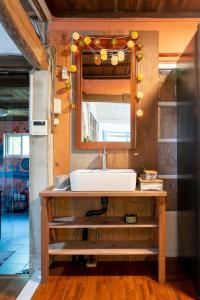 a bathroom with a sink and a mirror at 一棟貸し古民家月の桃 in Motobu +35 photos