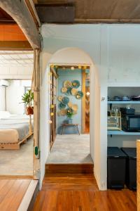 a hallway leading to a bedroom with a bed at 一棟貸し古民家月の桃 in Motobu