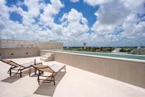 a patio with two chairs and a table on a roof at City escape in Cancún