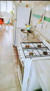 una cucina con piano cottura bianco forno superiore accanto a un frigorifero di A&C Temporarios III a Bañado Sur