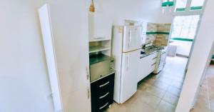 una cucina con elettrodomestici bianchi e frigorifero bianco di A&C Temporarios III a Bañado Sur