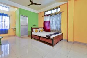a bedroom with a bed with green and yellow walls at Hotel O Homely Residency in Guwahati +21 photos