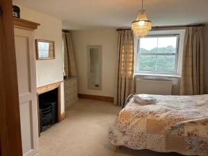 a bedroom with a bed and a fireplace and a chandelier at Beautiful farmhouse on a hill in Sandford