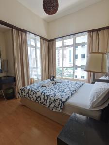a bedroom with a bed with a blue and white blanket at Seri Bukit Ceylon Kuala Lumpur in Kuala Lumpur