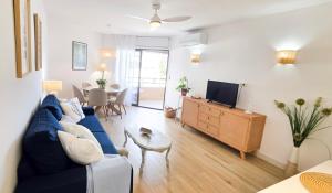 アルムニェーカルにあるVelilla Seaview with Pool and Parkingの青いソファとテレビのあるリビングルーム