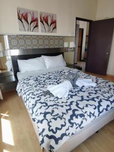 a bedroom with a bed with a blue and white blanket at Seri Bukit Ceylon Kuala Lumpur in Kuala Lumpur