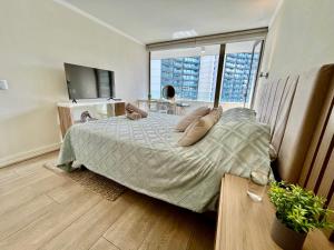 a bedroom with a bed and a large window at Apartamento Parque Arauco in Santiago +11 photos
