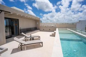 a rooftop patio with a swimming pool on a building at Nomad Studio Fast WiFi and Rooftop Pool in Cancún +22 photos