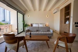 a living room with a couch and a table at Nomad Studio Fast WiFi and Rooftop Pool in Cancún