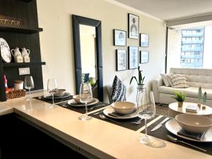 a living room with a table with wine glasses on it at Apartamento Parque Arauco in Santiago
