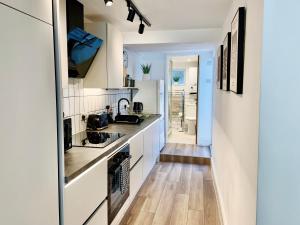 a kitchen with white cabinets and wood floors at 2-Bed Apartment - For Contractors & Business Travellers - Long Stays Welcome in Exeter