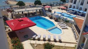 an overhead view of a swimming pool with a red umbrella at One More Day Hotel in Turgutreis