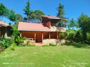 a house with a red roof and a yard at Mt Kenya Jim's Camp in Naro Moru