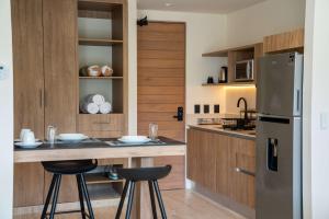 a kitchen with a counter with stools and a refrigerator at Versatile Studio Cowork Fast WiFi and Prime Location in Cancún