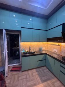 a kitchen with blue cabinets and a sink at Sunita Kunj in Jhūsi