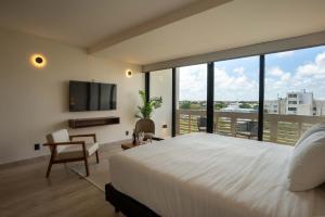 a bedroom with a large white bed and a large window at Work and Relax Studio with Rooftop and Workspace in Cancún