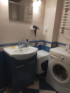 a bathroom with a sink and a washing machine at Apartament Niebieski Lwowska 56 in Nowy Sącz