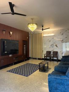 a living room with a couch and a tv at AC 3BHK premium house in Pollāchi