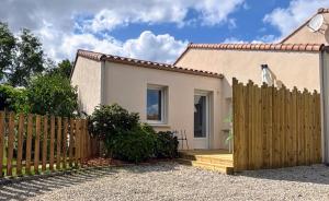 a wooden fence in front of a house at Gîte Cosy TY CLEM cottage in Mouilleron-le-Captif