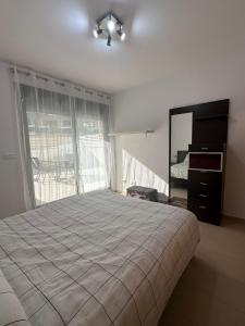 a bedroom with a bed and a dresser and a mirror at Ground floor apartment on the seafront with pool in Vinaròs +115 photos