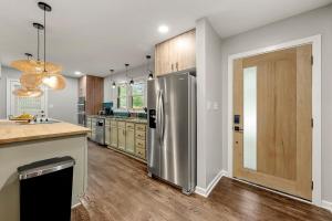 a kitchen with a stainless steel refrigerator and wooden cabinets at Elegant 5-Bedroom Luxury Haven by Deity Villas in Atlanta