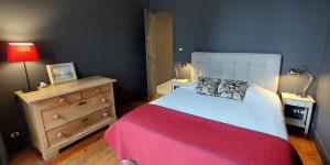 een slaapkamer met een bed, een dressoir en een lamp bij Burdigala Homes - Appart Clemenceau in Bordeaux