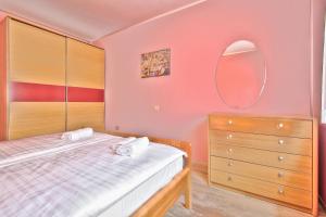 a bedroom with a bed and a dresser and a mirror at Schöne Ferienvilla Morena Mit Pool in Kaštel