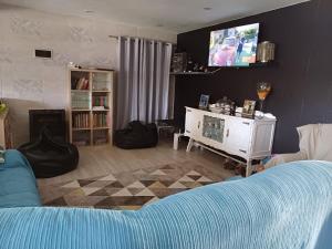 a living room with a couch and a tv at Twin Room Sofia's Happy House WC Privada Porta ao lado in Aldeia dos Fernandes
