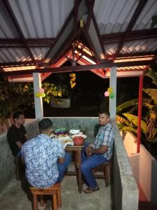 a group of men sitting at a table in a patio at Villa sea 40 in Wenamulla +25 photos