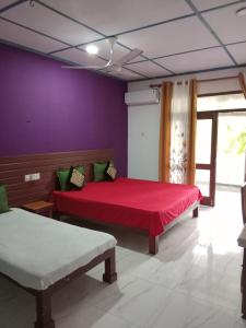 a bedroom with two beds and a purple wall at Villa sea 40 in Wenamulla
