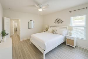 Un dormitorio blanco con una cama y un ventilador de techo. en The Sandpiper Hideaway - Community Pool, en Santa Rosa Beach 33 fotos más