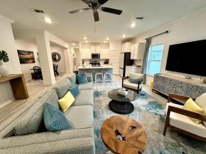 sala de estar con sofá y TV y cocina en The Sandpiper Hideaway - Community Pool, en Santa Rosa Beach