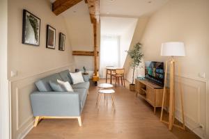 a living room with a couch and a tv at L'Eclat des Halles - Hypercentre in Amiens