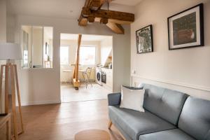 a living room with a blue couch and a kitchen at L'Eclat des Halles - Hypercentre in Amiens
