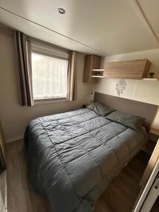 a bed in a small room with a window at Mobil-Home 3ch 8 pers - Les Charmettes K100 - Les Mathes in Les Mathes +28 photos