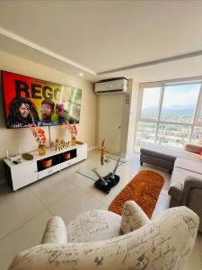 ein Wohnzimmer mit Couch und Fernseher in der Unterkunft Spacious two bedrooms with sea and city view in Portmore