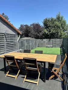 ein Holztisch mit vier Stühlen um ihn herum in der Unterkunft Love Room Paradise in Saint-Genest-Lerpt